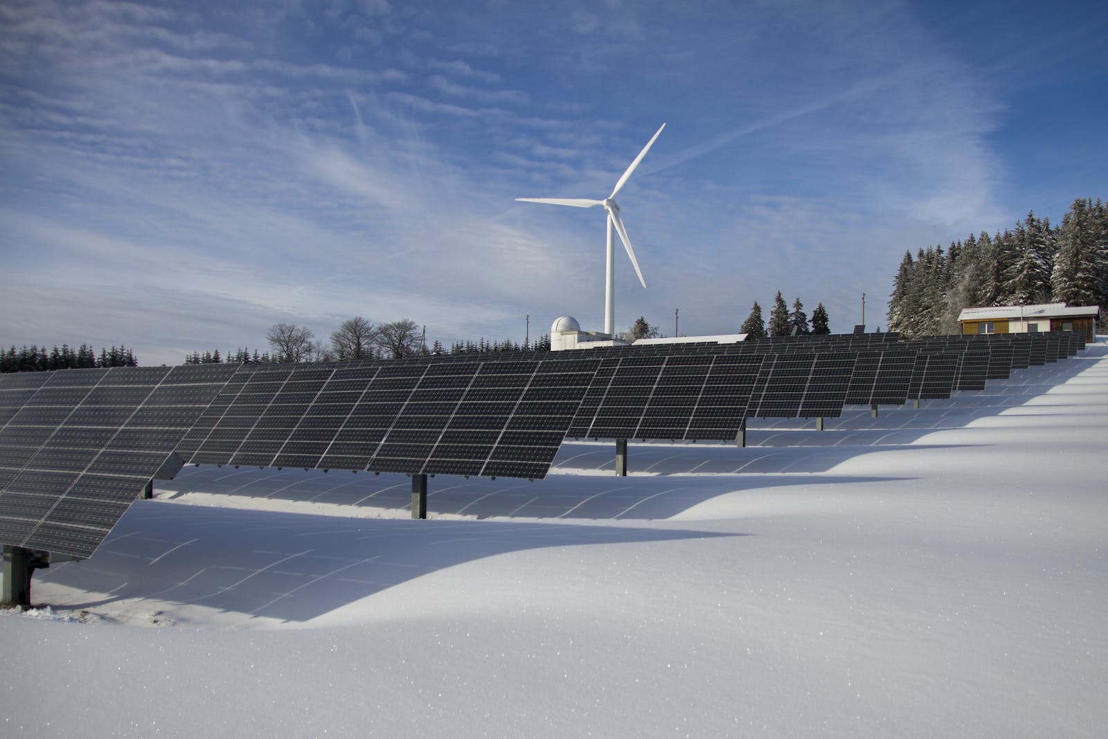 Solar Panels on Snow With Windmill Under Clear Day Sky, Environmental Services Industry